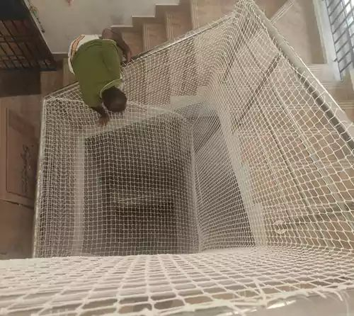 Worker installing safety netting on a staircase